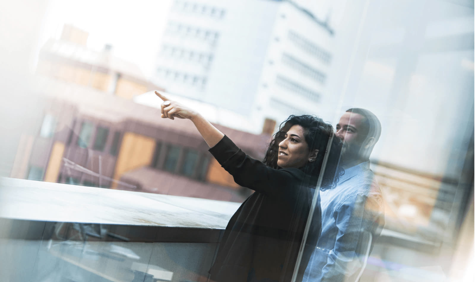 Zwei Menschen blicken aus dem Bürofenster über Kassel